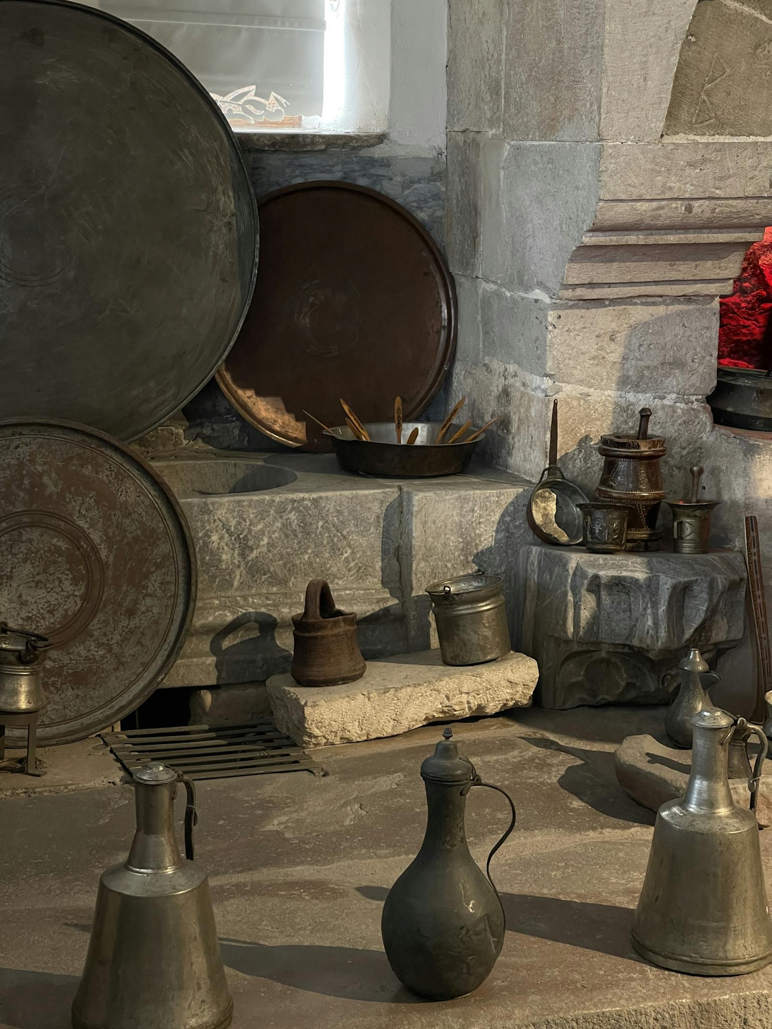 Collection of vintage metal and iron kitchenware in a historic Konya, Türkiye setting.